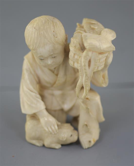 A Japanese ivory okimono of a boy with a dog, Meiji period, height 7.5cm excl. wood stand